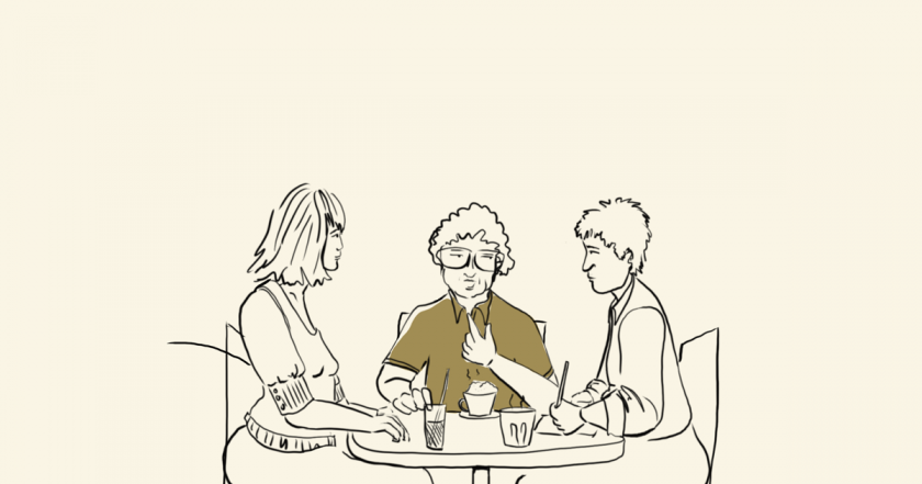 Three people talking in a café.